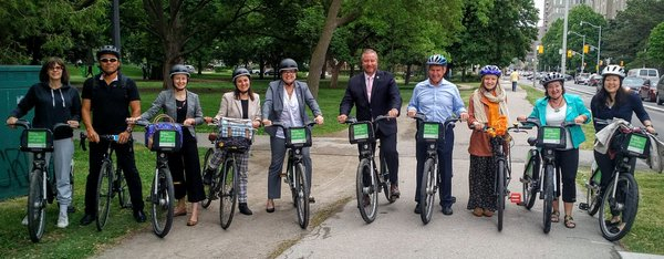 A group of advocates on bicycles, smiling for the camera.